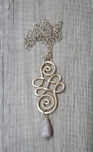 Collana dorata doppia spirale con pietra rosa in ceramica